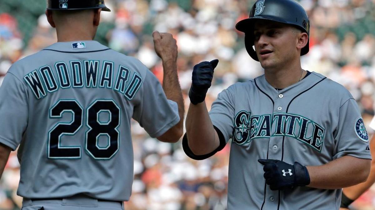 
Seattle Mariners' Kyle Seager, right, celebrates with first base coach Chris Woodward after hitting an one-run single during the eighth inning of a baseball game against the Chicago White Sox, Sunday, Aug. 30, 2015, in Chicago.
