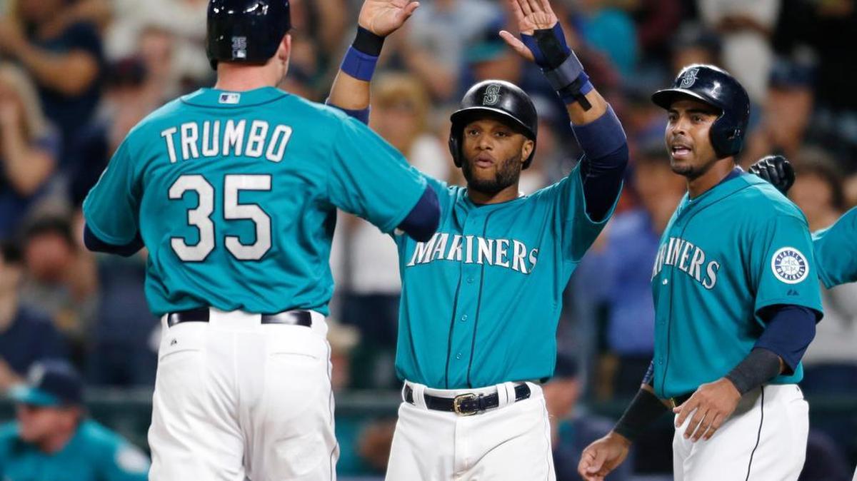 
Mark Trumbo is greeted by Mariners teammates Robinson Cano, center, and Nelson Cruz after a three-run home run in the seventh inning.
