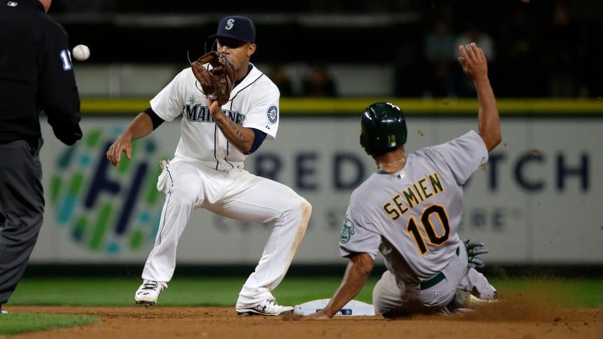 
Mariners shortstop Ketel Marte, left, makes the catch before tagging out the Athletics’ Marcus Semien as he tries to steal second base in the eighth inning Saturday. Semien ended up hitting the game-winning home run in the 13th inning as the A’s won, 7-5.
