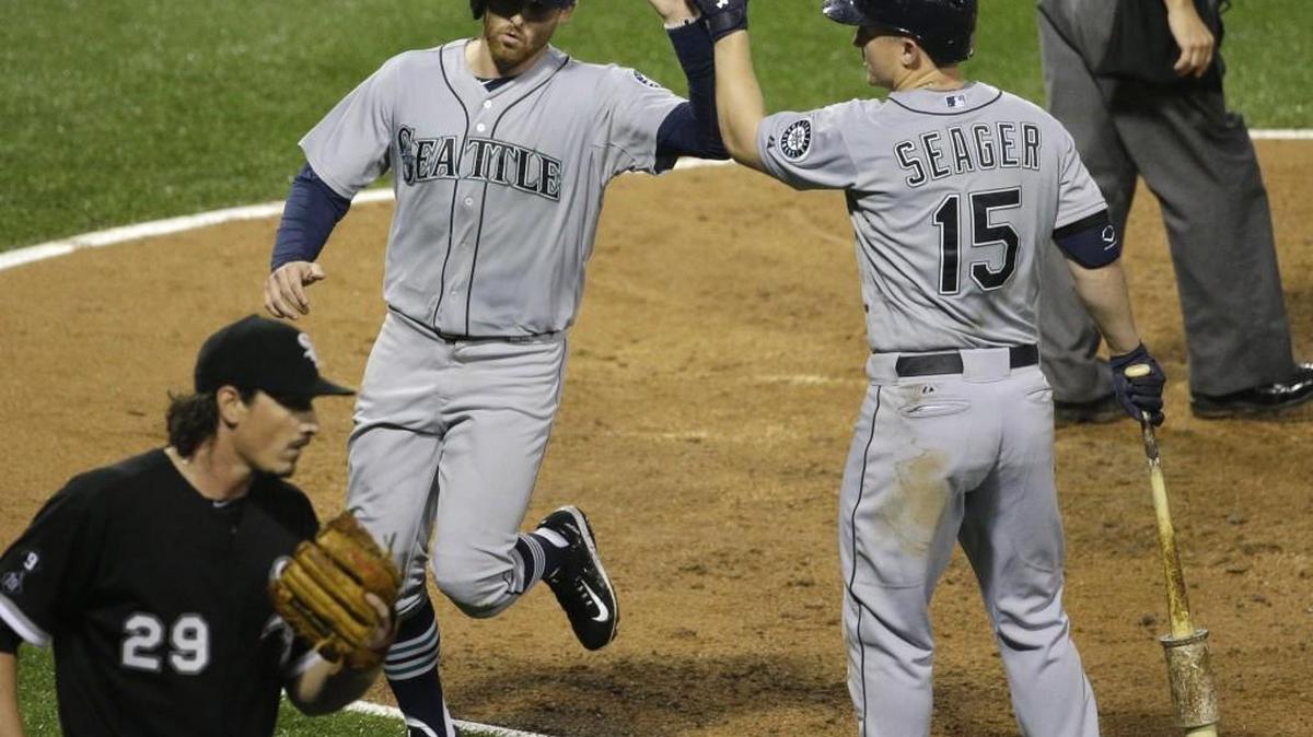 
Seattle’s Brad Miller, left, celebrates with Kyle Seager after scoring on a sacrifice fly by Ketel Marte off Chicago White Sox starter Jeff Samardzija (29) during the fourth inning of the Mariners victory Saturday in Chicago.
