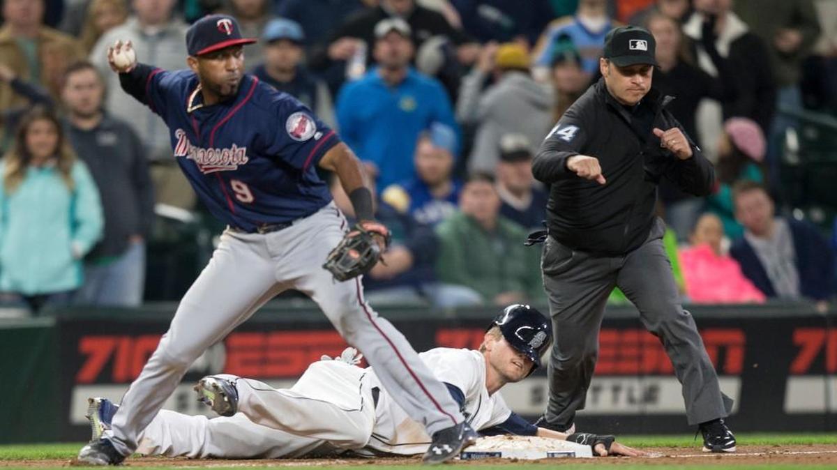 Seattle Mariners' Shawn O'Malley lays on the ground after being tagged out caught stealing by Minnesota Twins third baseman Eduardo Nunez who threw to second to complete a double play in the ninth inning of a baseball game, on Saturday, May 28, 2016, in Seattle. The Twins won 6-5.