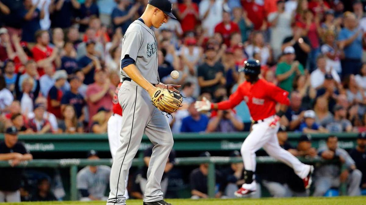 
Seattle Mariners starting pitcher Mike Montgomery tosses a new ball in the air as Boston Red Sox's Rusney Castillo, right, rounds the bases after his two-run home run during the first inning of a baseball game at Fenway Park in Boston Friday, Aug. 14, 2015.
