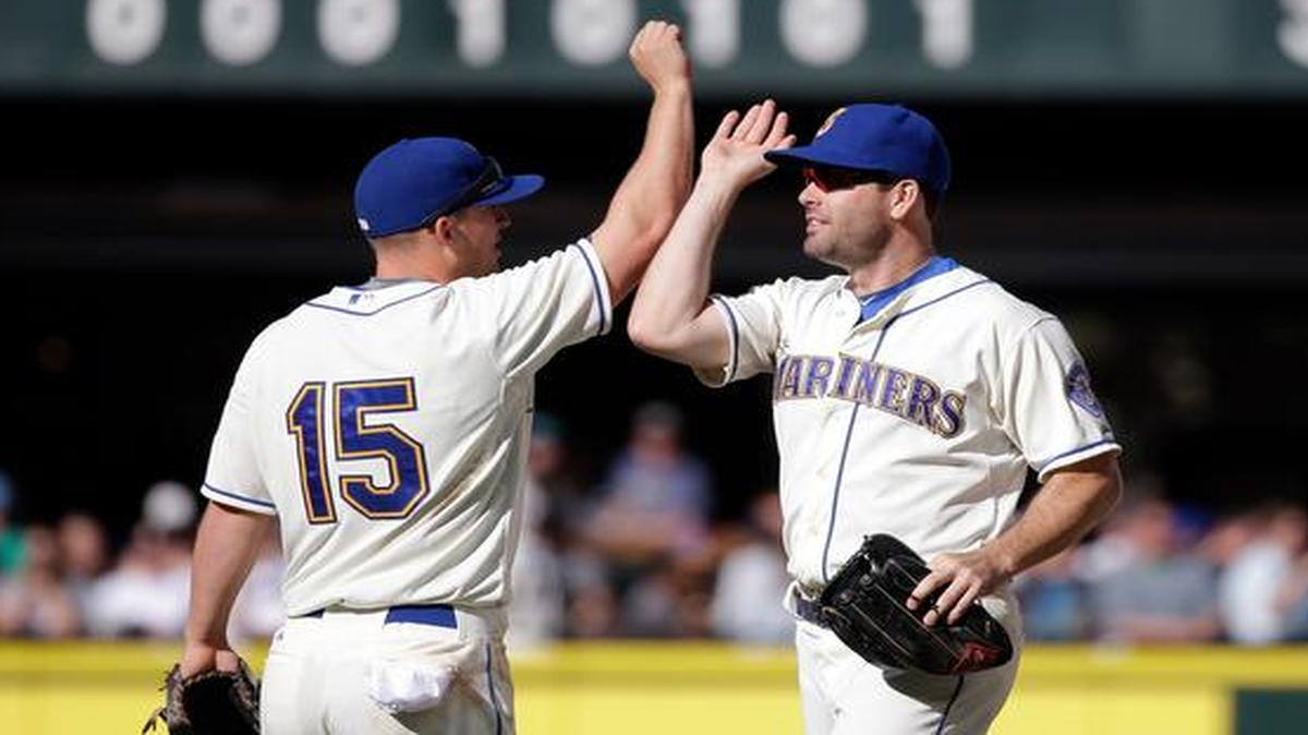 
Mariners third baseman Kyle Seager (15) and outfielder Seth Smith celebrate after winning the final game of the season Sunday, 3-2, against the Athletics at Safeco Field.
