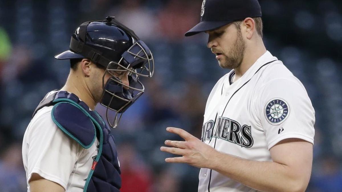 
Mariners catcher Mike Zunino and starting pitcher James Paxton look at Paxton’s pitching hand in the fifth inning May 28. Paxton left the game and has not pitched in the big leagues since. He’s in line to pitch Sunday against Colorado.
