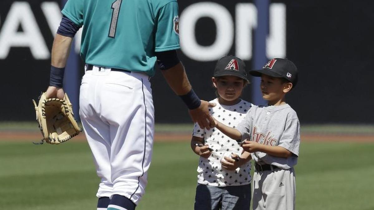 Seattle Mariners' Chris Taylor signs autographs for young fans before a spring training game Sunday against the Reds. (AP Photo/Darron Cummings)