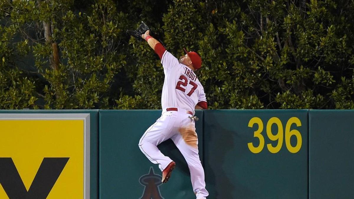 
Mike Trout of the Angels makes an over-the-fence catch on a ball hit by the Mariners’ Jesus Montero during the fourth inning Saturday in Anaheim, Calif. The catch turned what would have been a three-run homer into a harmless out.
