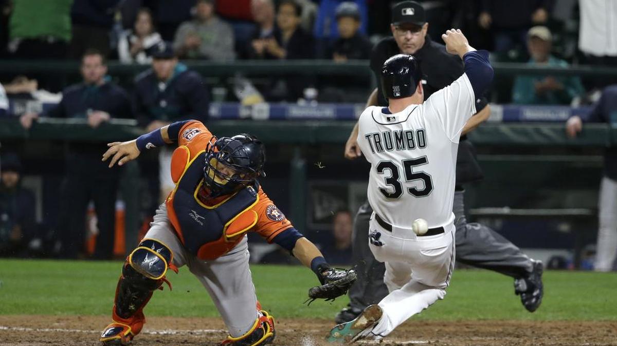 
Seattle’s Mark Trumbo, right, avoids the tag of Astros catcher Hank Conger to score on a single by Shawn O’Malley in the eighth inning. 
