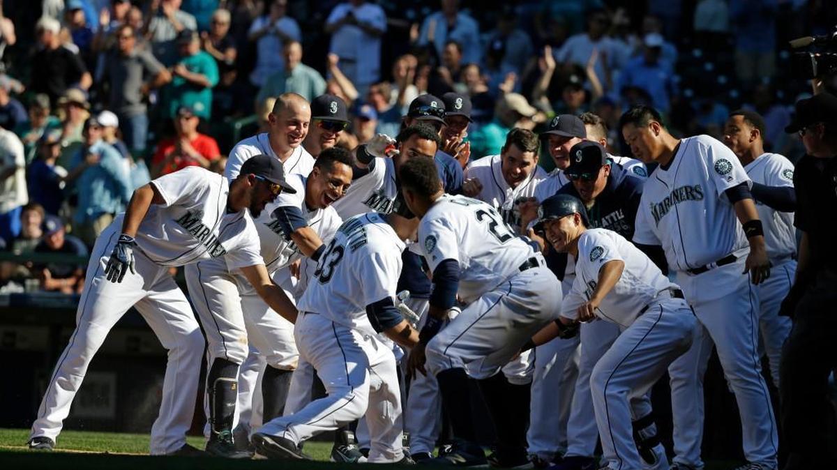 The Mariners mobbed Chris Iannetta at the plate after his walk-off homer in the 11th inning.