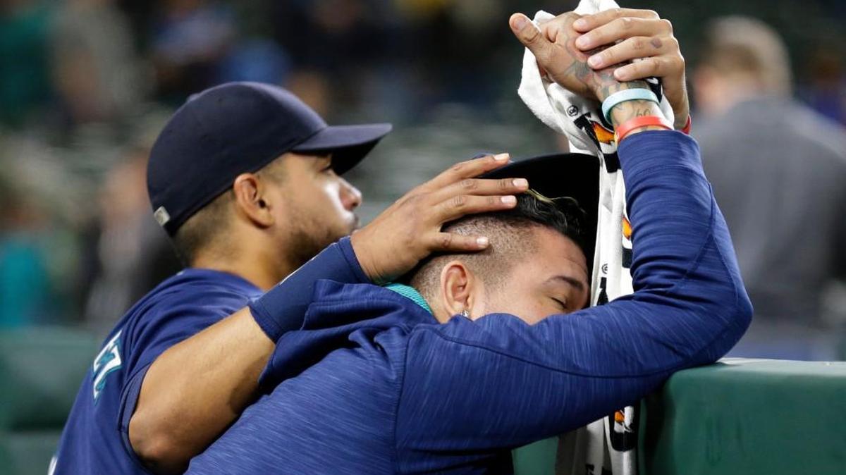 Outfielder Franklin Gutierrez consoled pitcher Felix Hernandez after Saturday’s loss to Oakland, which eliminated the Mariners from postseason competition.