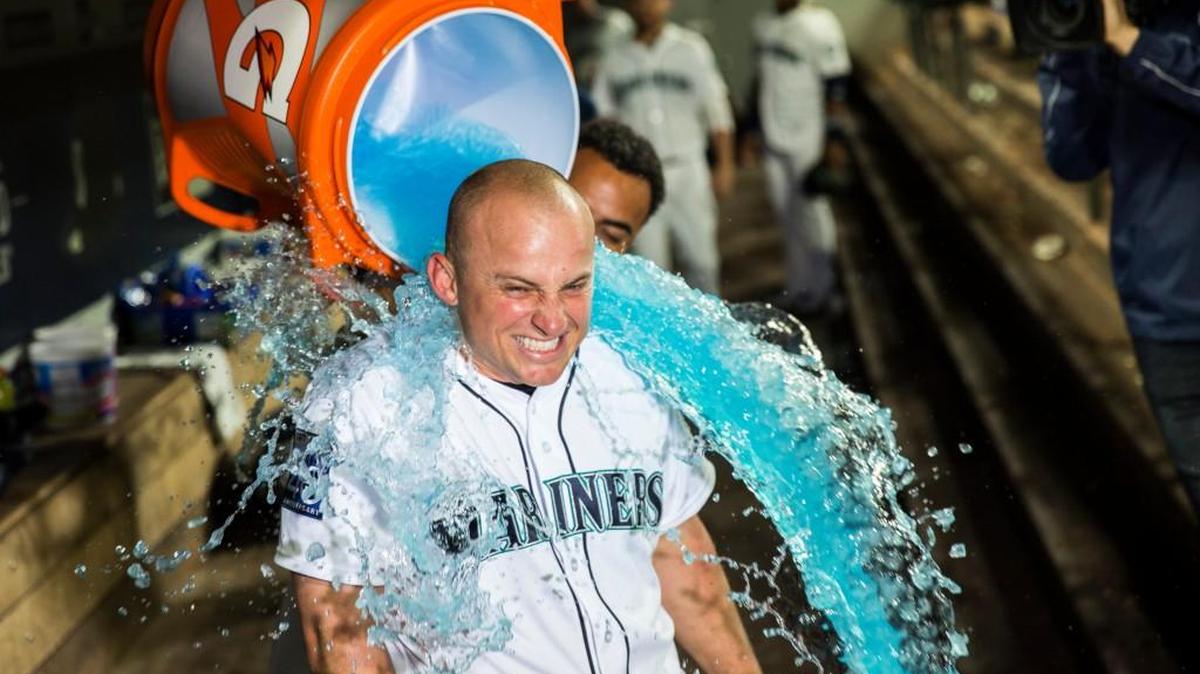 Kyle Seager experiences the blue wave, courtesy of Nelson Cruz, after hitting a walk-off RBI double for a 5-4 victory over Detroit in 10 innings.