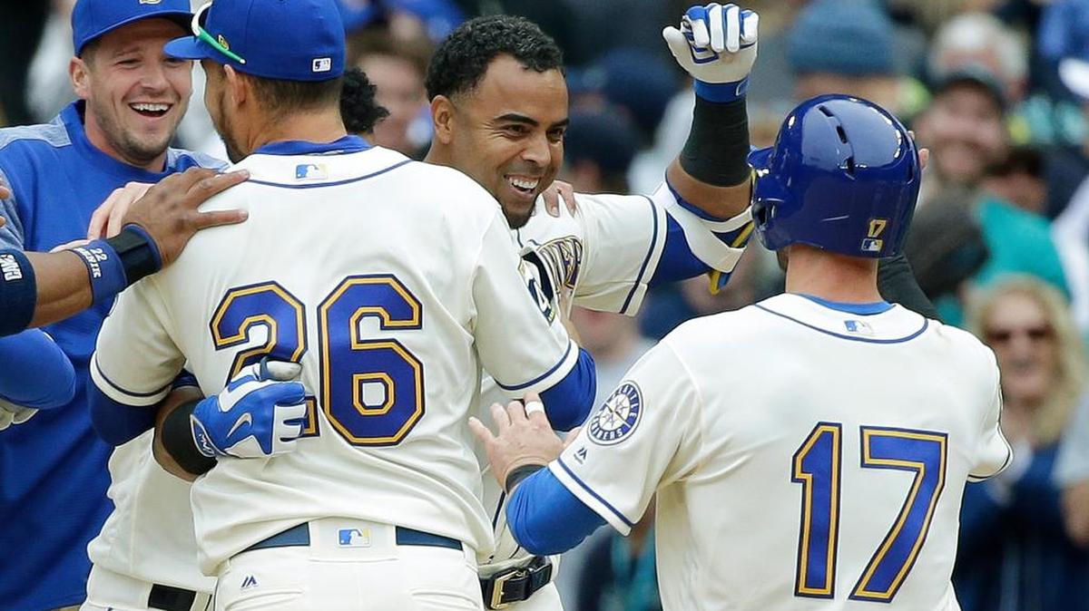 Nelson Cruz, center, is greeted by Mitch Haniger (17) and other teammates after his walk-off RBI single in the ninth inning gave the Mariners a come-from-behind 8-7 win over the Rangers on Sunday. The Mariners swept a series from the AL West champions for the first time since 2015.