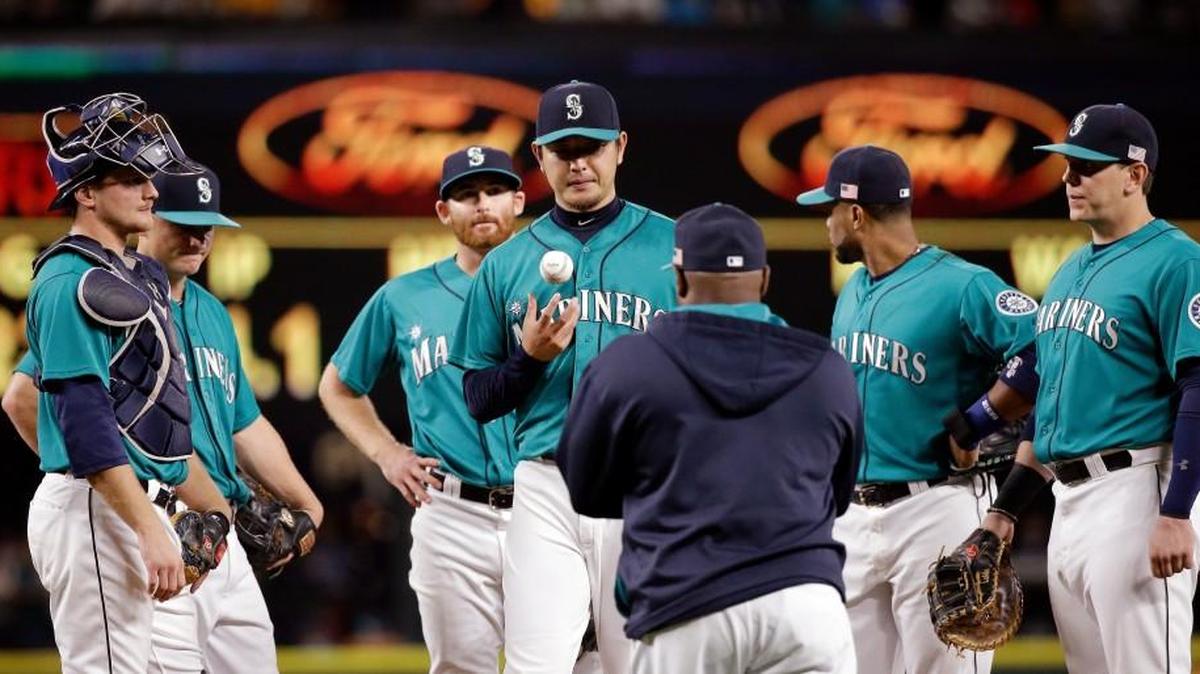 
Seattle Mariners starting pitcher Hisashi Iwakuma, center, waits with infielders to be relieved by manager Lloyd McClendon during the seventh inning against the Colorado Rockies in a baseball game Friday, Sept. 11, 2015, in Seattle.
