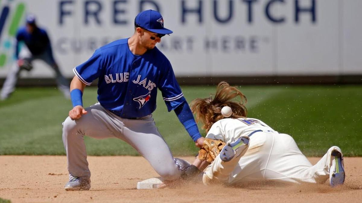 The ball bounces from the glove of Toronto shortstop Troy Tulowitzki and onto the back of Seattle’s Ben Gamel on Sunday as Gamel steals second base in the seventh inning in Seattle.