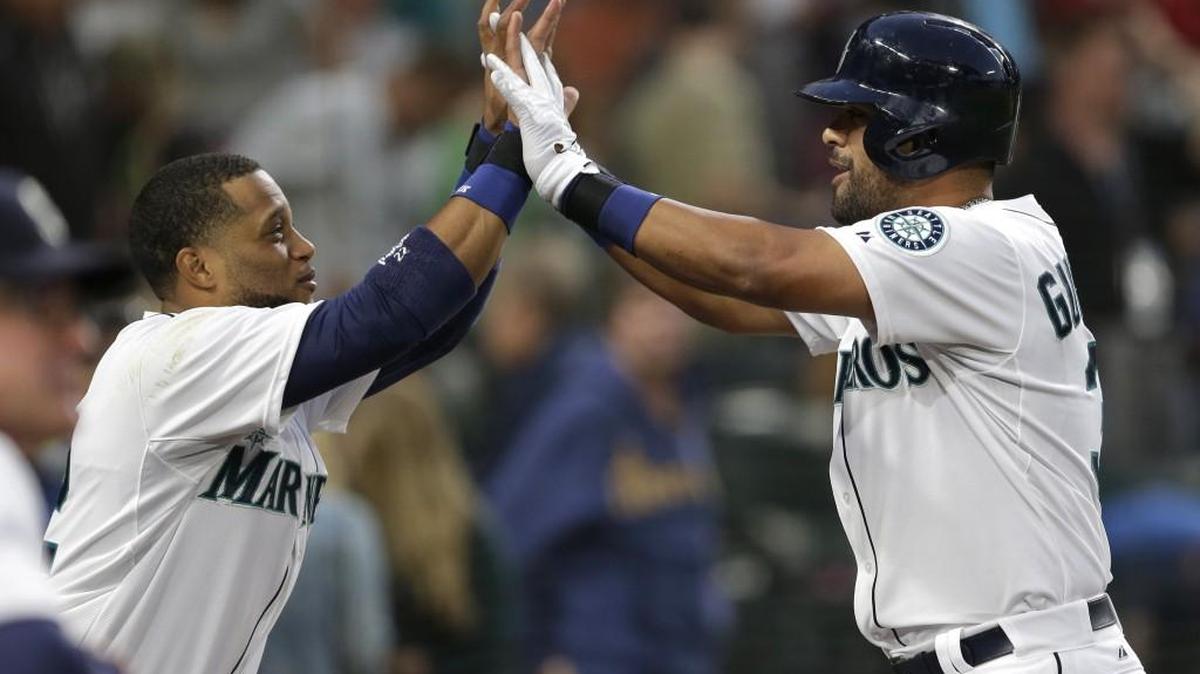 
Franklin Gutierrez, right, is greeted by Mariners teammate Robinson Cano after Gutierrez hit a solo home run against the Colorado Rockies in the fifth inning Saturday, Sept. 12, 2015, in Seattle.
