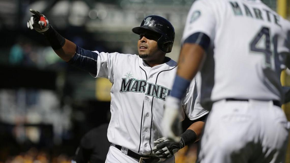 Seattle Mariners' Nelson Cruz reacts as he reaches home plate after hitting a two-run home run that also scored Ketel Marte (4) against Texas on Sept. 10.