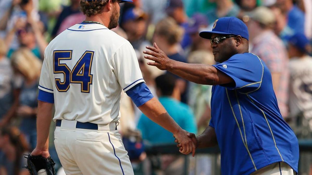 
Seattle Mariners reliever Tom Wilhelmsen (54) is congratulated by manager Lloyd McClendon after the 8-6 win over the Chicago White Sox on Sunday.
