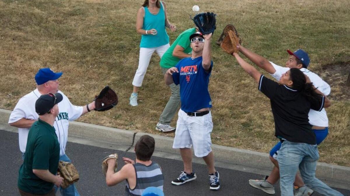 Fans outside the stadium go after a home run ball during the Minor League Baseball Home Run Derby at Cheney Stadium in Tacoma on Monday, July 10, 2017.