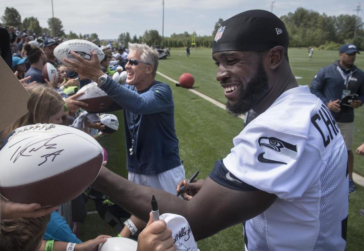 Seahawks head coach Pete Carroll and now-injured safety Kam Chancellor sign autographs for fans following practice on the opening day of 2016's training camp at the team's Virginia Mason Athletic Complex in Renton.