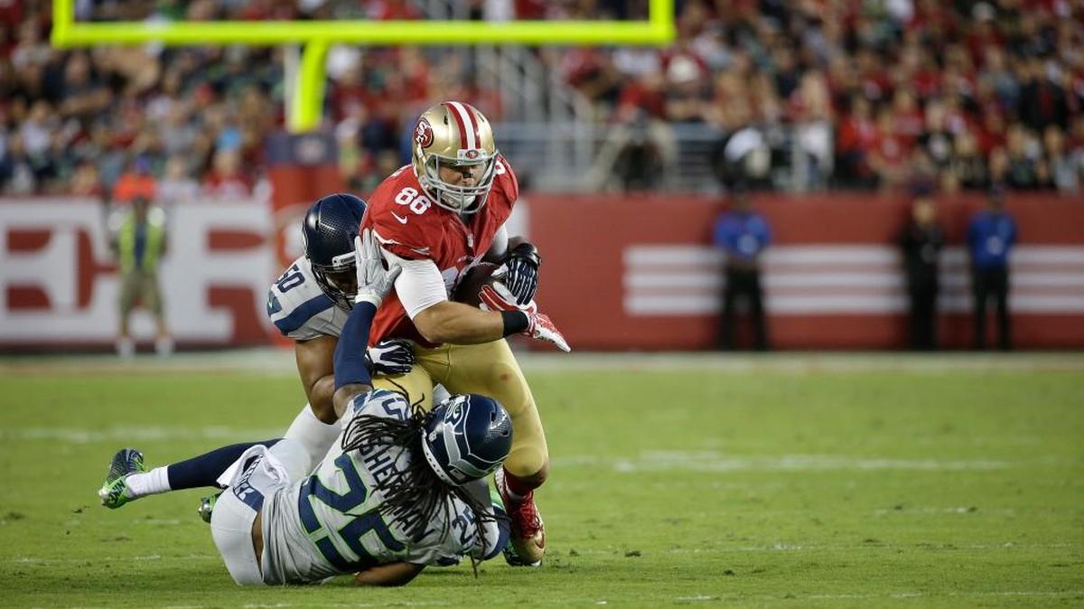 San Francisco 49ers tight end Garrett Celek (88) is tackled by Seattle Seahawks cornerback Richard Sherman (25) and outside linebacker K.J. Wright (50) during the first half of an NFL football game in Santa Clara, Calif., Thursday, Oct. 22, 2015.