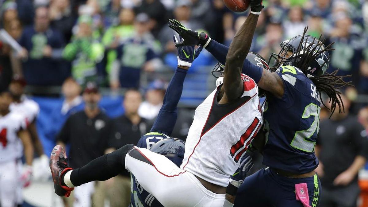 Seattle’s Richard Sherman, right, and Earl Thomas, obscured, break up a pass intended for Atlanta’s Julio Jones on the Falcons’ final play last weekend. Sherman was faulted for possible pass interference on the play, but countered that Jones head-slapped him and didn’t draw a flag.