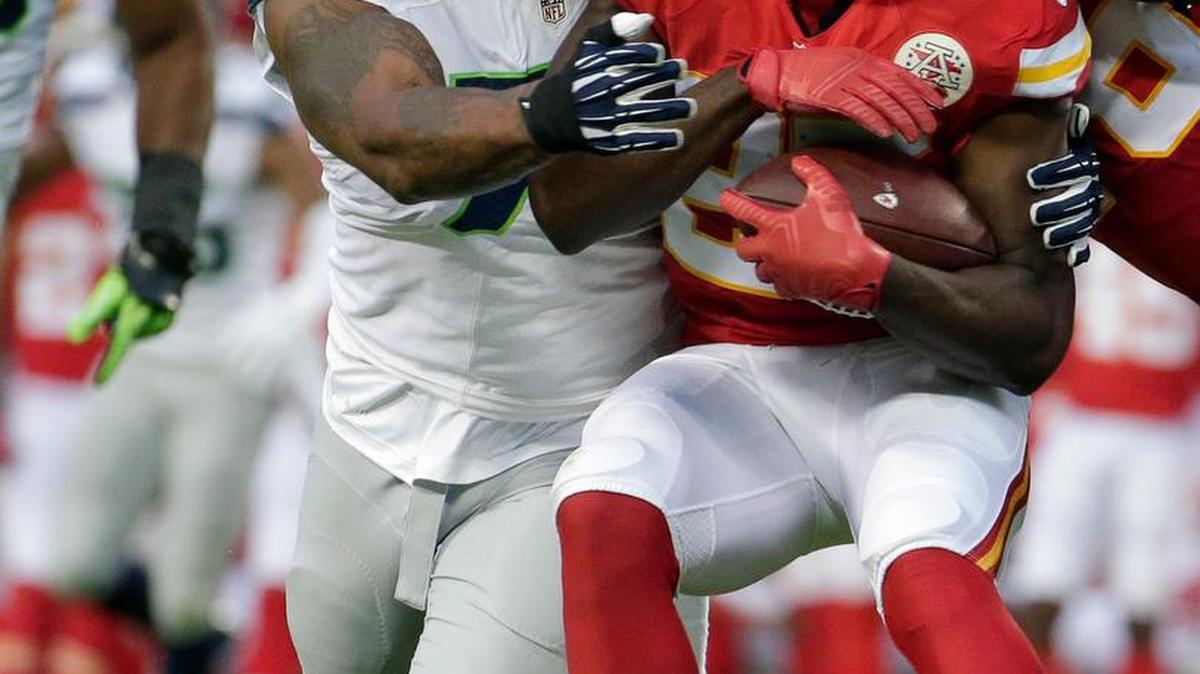 
Kansas City Chiefs running back Jamaal Charles (25) is tackled by Seattle Seahawks defensive end Michael Bennett (72) during the first half of an NFL football game at Arrowhead Stadium in Kansas City, Mo., Friday, Aug. 21, 2015.
