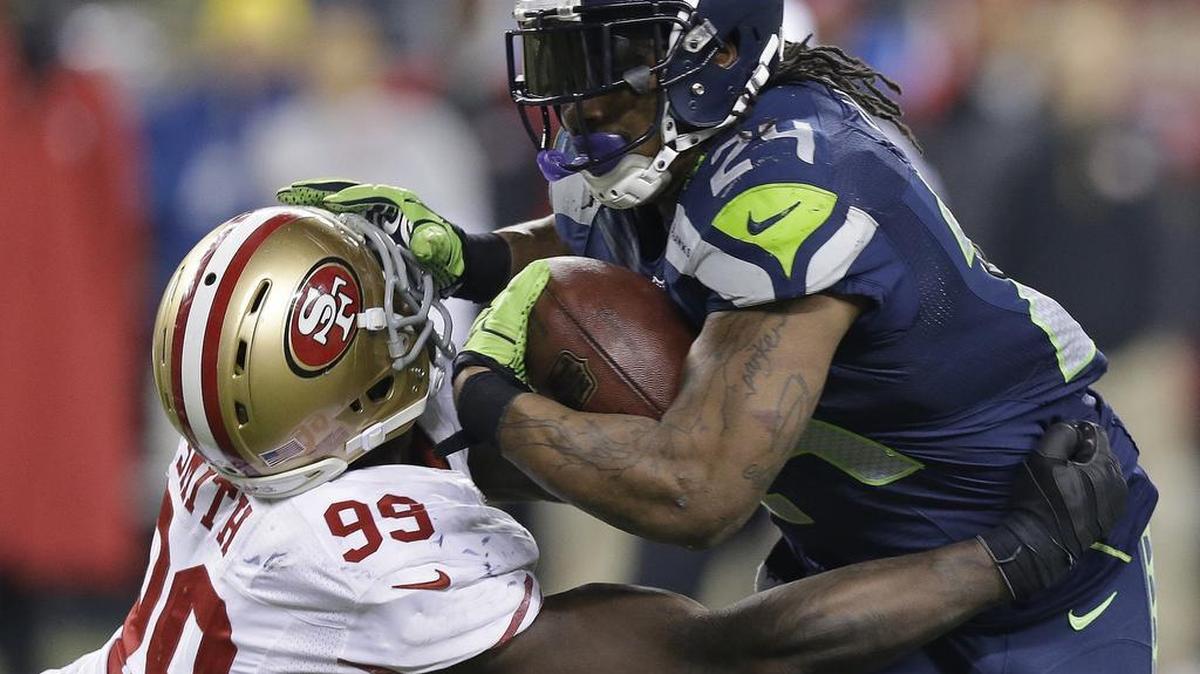 Seattle Seahawks’ Marshawn Lynch tries to run past San Francisco 49ers’ Aldon Smith during the second half of the NFL football NFC Championship game Sunday, Jan. 19, 2014, in Seattle. (AP Photo/Elaine Thompson)