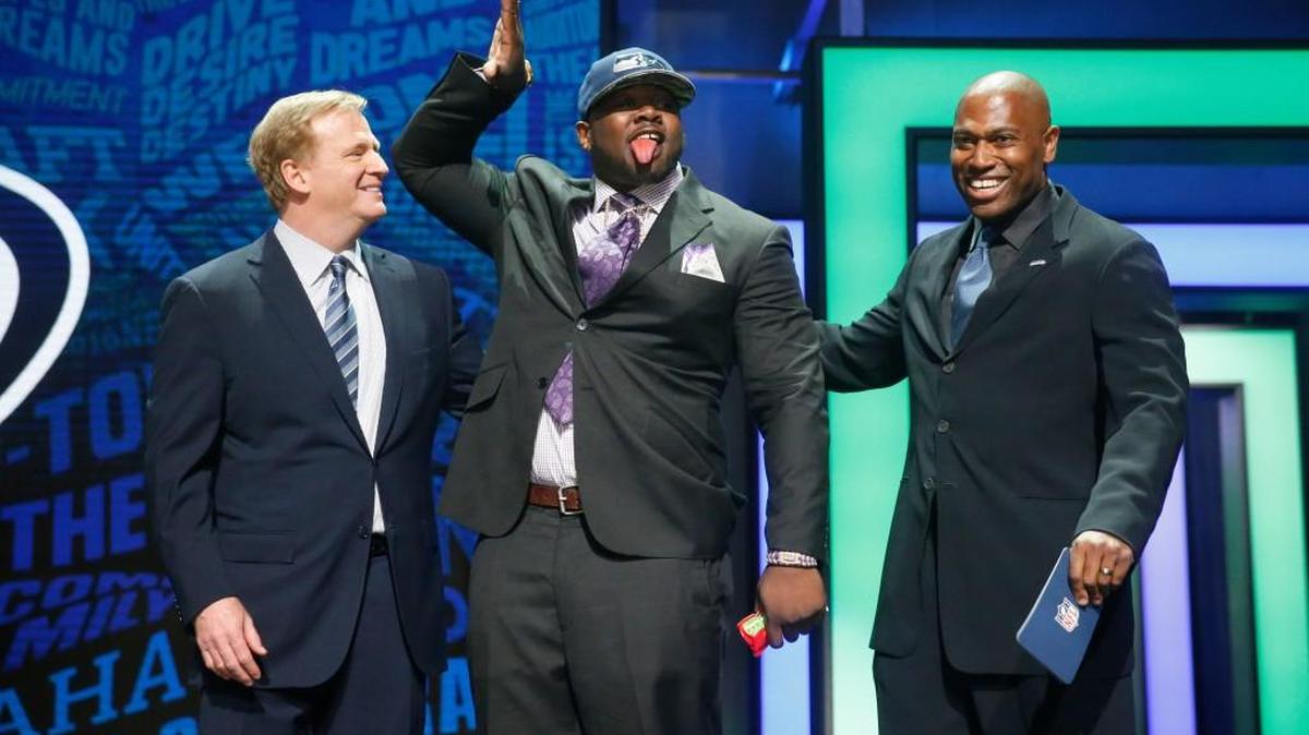 Alabama nose tackle Jarran Reed, center, poses for photos with NFL Commissioner Roger Goodell, left, and former Seahawks running back Shaun Alexander after being selected by Seattle as the 49th pick in the second round of the NFL draft in Chicago.