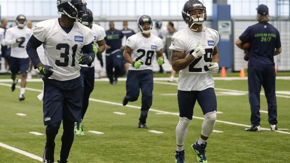 
Seattle Seahawks safety Earl Thomas, right, jogs on the field with Seahawks strong safety Kam Chancellor (31) after an organized team activity in June. Chancellor’s holdout for more money from the Seahawks reached its 25th day Monday. 

