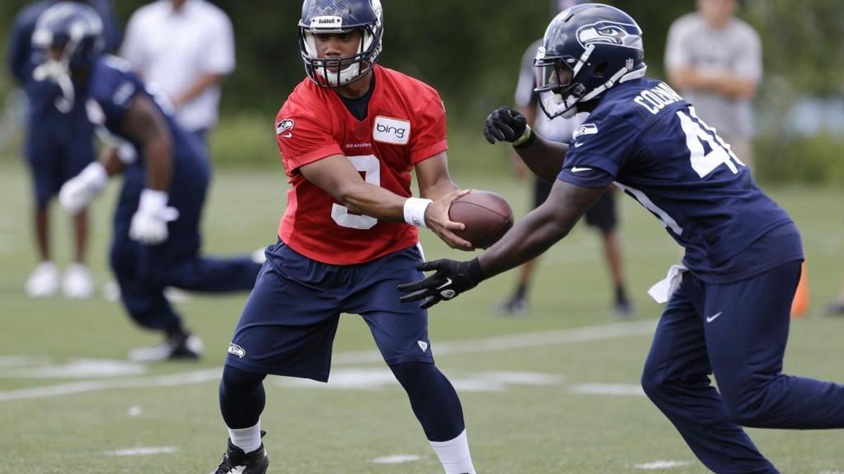 Seahawks fullback Derrick Coleman, right, takes a handoff from quarterback Russell Wilson during a practice in 2013. Bellevue police chief Steve Mylett says his department did not purposely drag out the investigation into Coleman’s car crash.