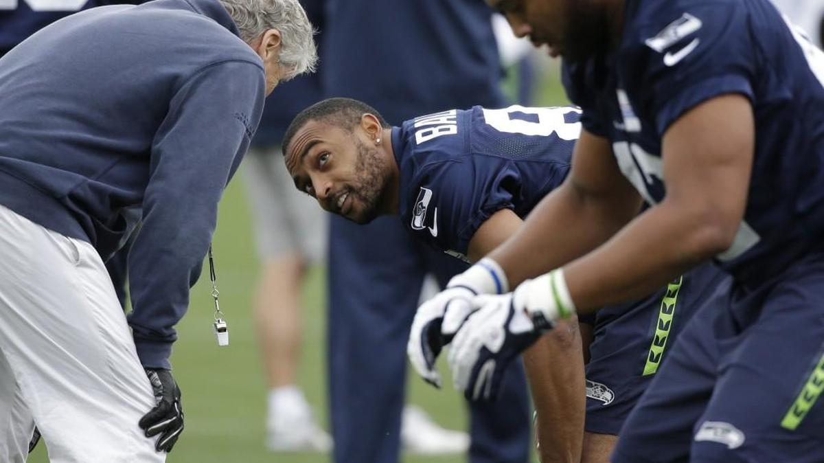 Seattle Seahawks head coach Pete Carroll, left, talks with Doug Baldwin at a workout on May 26 in Renton. Baldwin might not seem as angry as in past years, but don’t mistake that for a lack of competitiveness, he says.