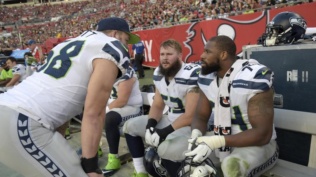 Seattle Seahawks center Justin Britt, left, talks with offensive guard Mark Glowinski, center, and offensive tackle George Fant on the bench during the first half against Tampa Bay this past Sunday. Britt returns to center against the Carolina Panthers on Sunday night.