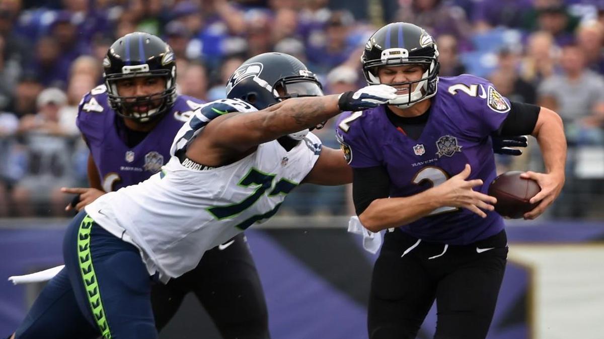 Seattle’s Michael Bennett closes in on Baltimore quarterback Jimmy Clausen in the first quarter. Bennett finished with four tackles, three solo, one sack and one tackle for loss.
