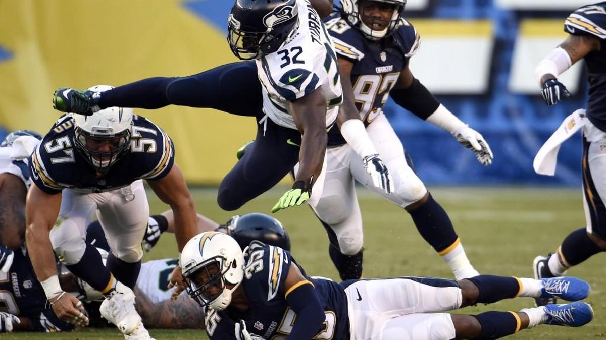 
Seattle Seahawks running back Robert Turbin (32) leaps over San Diego Chargers cornerback Richard Crawford (35) during the second half of a preseason game on Aug. 29 in San Diego. 
