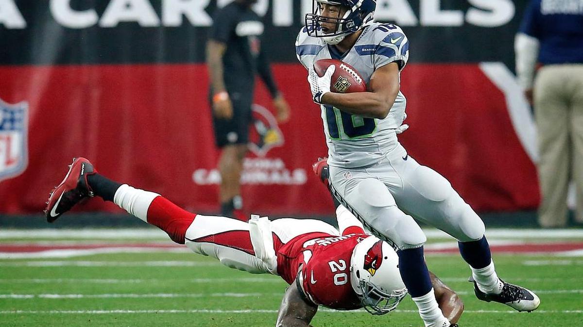 Seattle’s Tyler Lockett dodges an attempted tackle by Arizona’s Deone Bucannon in the first half. “I think he’s rookie of the year,” Russell Wilson says of Lockett.