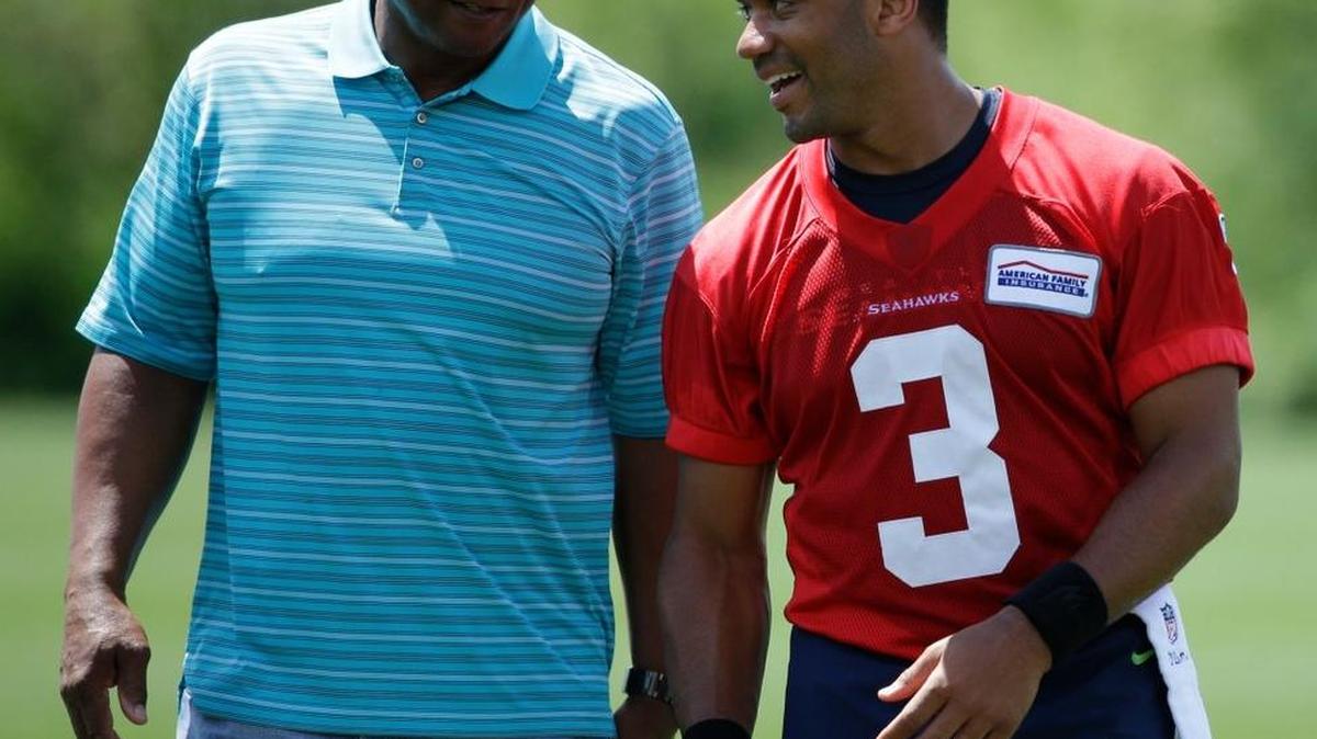 Seattle quarterback Russell Wilson, right, walks off the field with Warren Moon on Friday following practice in Renton.