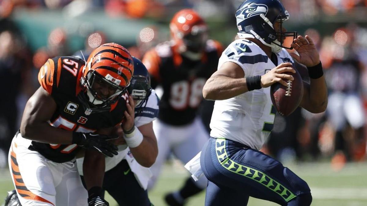 
Seattle Seahawks quarterback Russell Wilson, right, runs the ball in the first half of an NFL football game against the Cincinnati Bengals, Sunday, Oct. 11, 2015, in Cincinnati.
