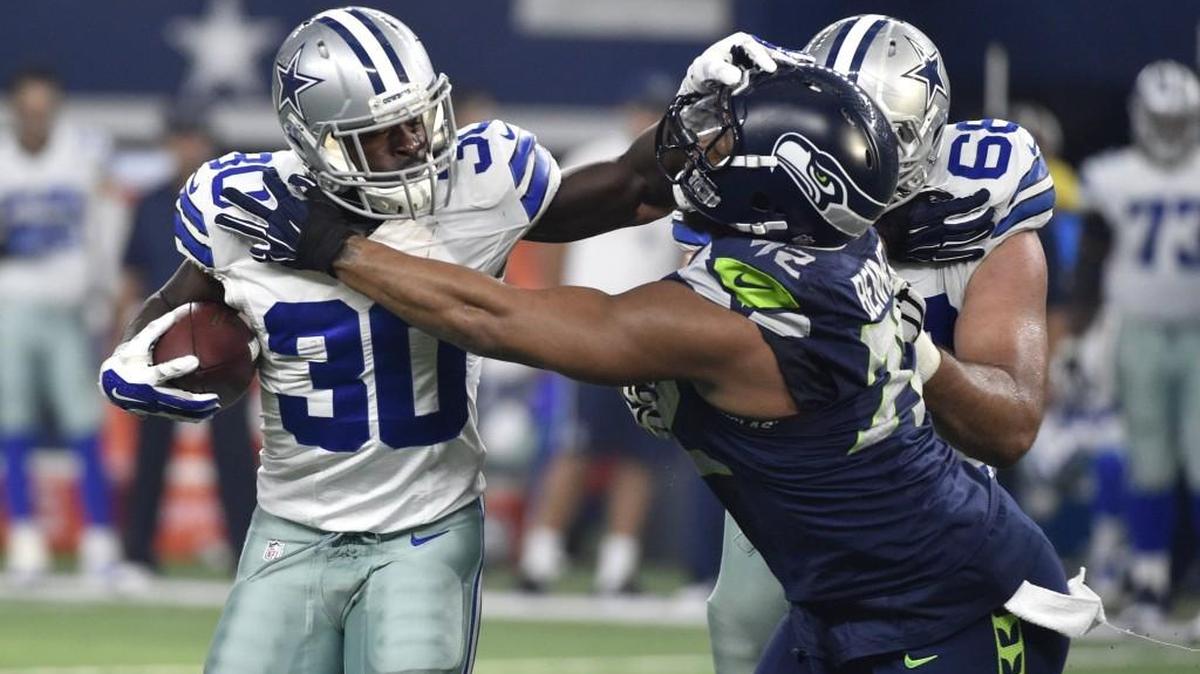 Dallas Cowboys' Christine Michael fights off a tackle by the Seahawks defensive end Michael Bennett when the teams played in November. Michael was re-signed by Seattle on Wednesday.