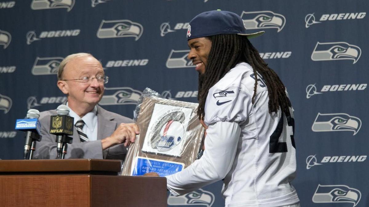 John Clayton presents Seattle cornerback Richard Sherman with the Pro Football Writers of America (PFWA) 2015 Good Guy Award from at the Seahawks headquarters in Renton on Wednesday, Sept. 23, 2015.