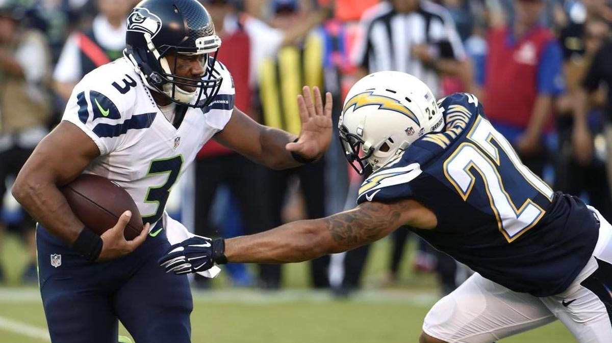 
Seattle Seahawks quarterback Russell Wilson, left, runs past San Diego Chargers defensive back Jimmy Wilson during the first half of an NFL preseason football game Saturday, Aug. 29, 2015, in San Diego.
