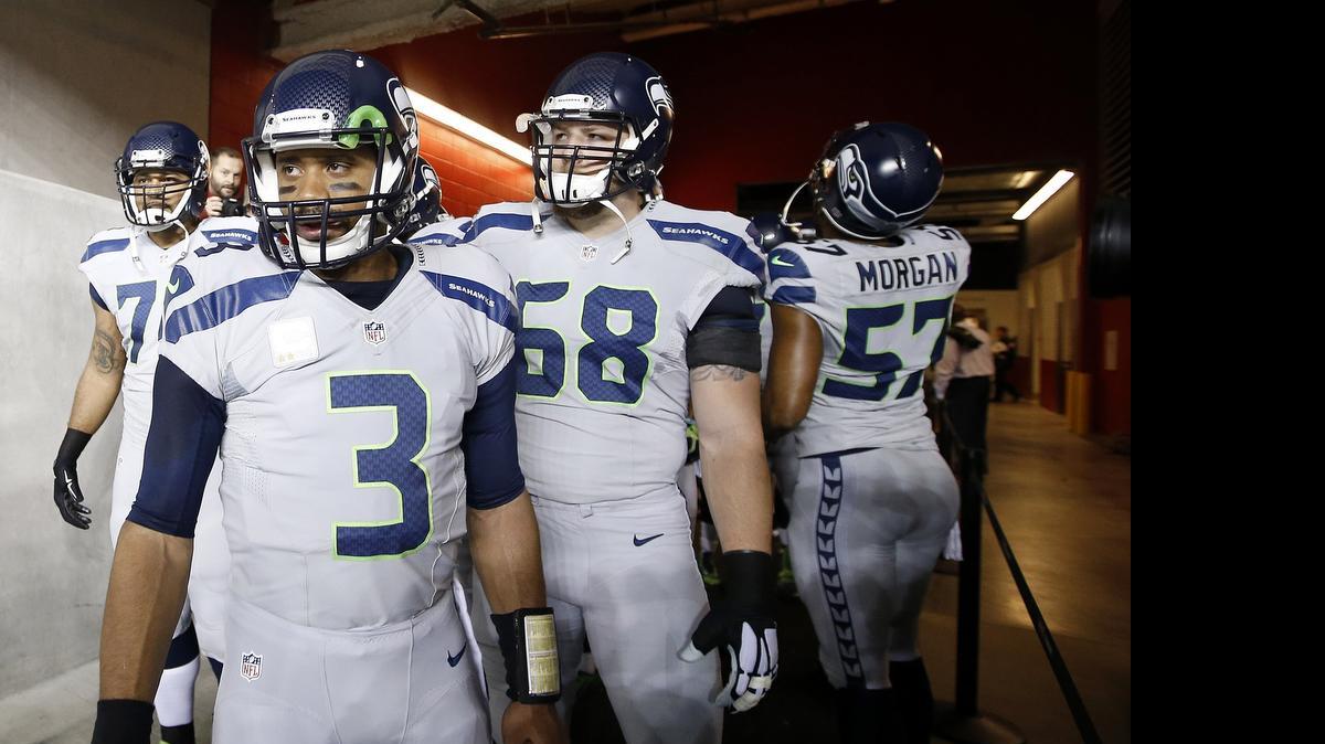 
Seattle quarterback Russell Wilson (3), standing with tackles Garry Gilliam, left, and Justin Britt (68), gets chased out of the pocket more than he should. That means the Seahawks need to devote even more energy to patching a line that has lost two starters. 
