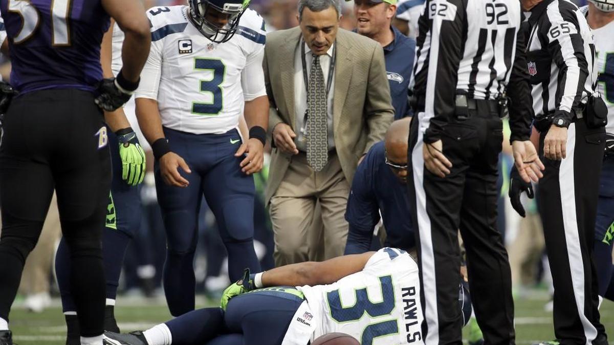 Seattle Seahawks quarterback Russell Wilson (3) looks at an injured Seahawks running back Thomas Rawls (34) during the first half an NFL football game against the Baltimore Ravens, Sunday, Dec. 13, 2015, in Baltimore. Rawls will miss the rest of the season with a broken ankle.