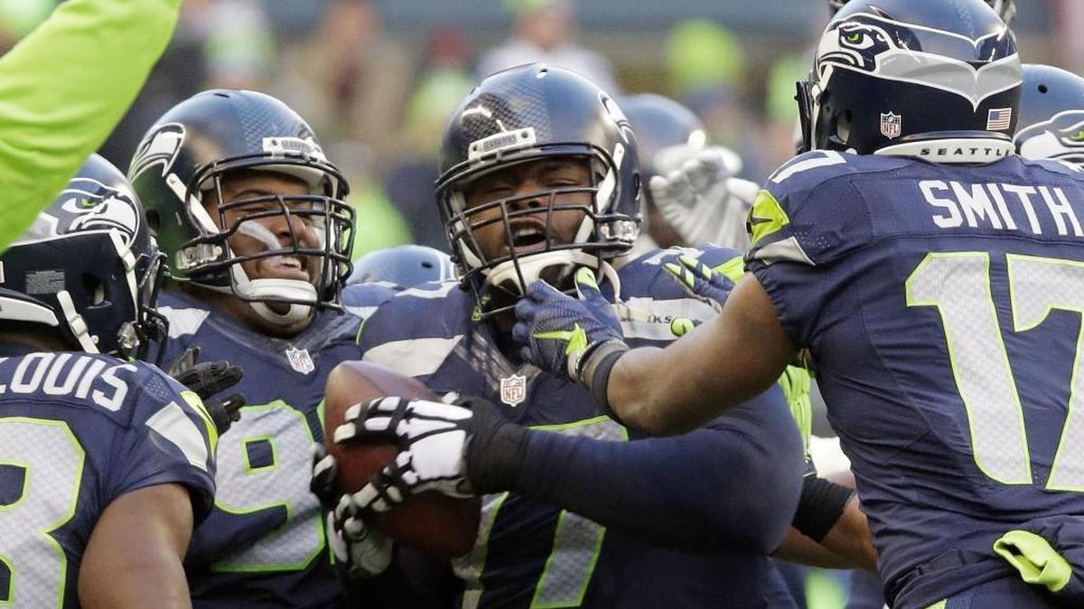 Ahtyba Rubin, here in the center of Seahawks teammates after his second career interception in November against Pittsburgh, has agreed to return to Seattle with a three-year contract. It keeps a key to the team’s top-ranked run defense from free agency.