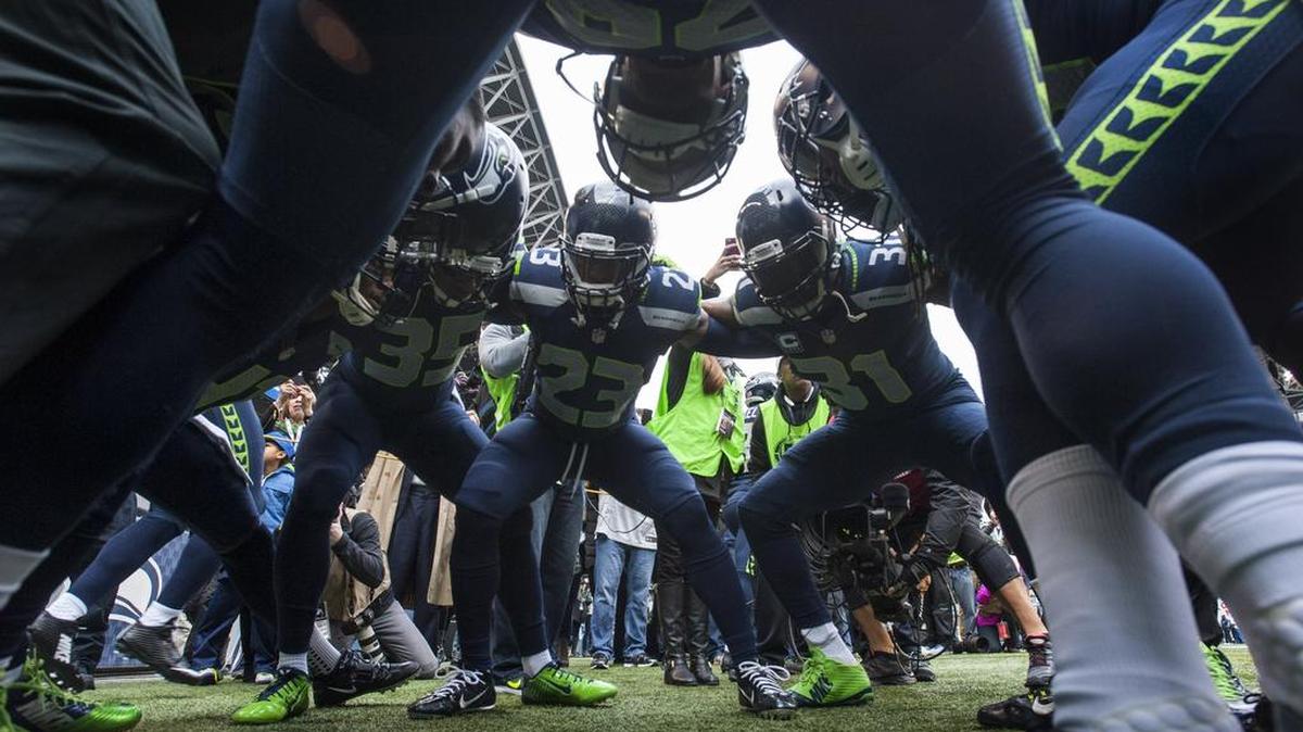 
DeShawn Shead (35) and Kam Chancellor (31) with fellow defensive backs before the 2014 regular-season finale against St. Louis at CenturyLink Field in Seattle. Shead says Chancellor is “still very active” in Seahawks’ training camp despite his holdout that is eight days old, reviewing films of practices. 
