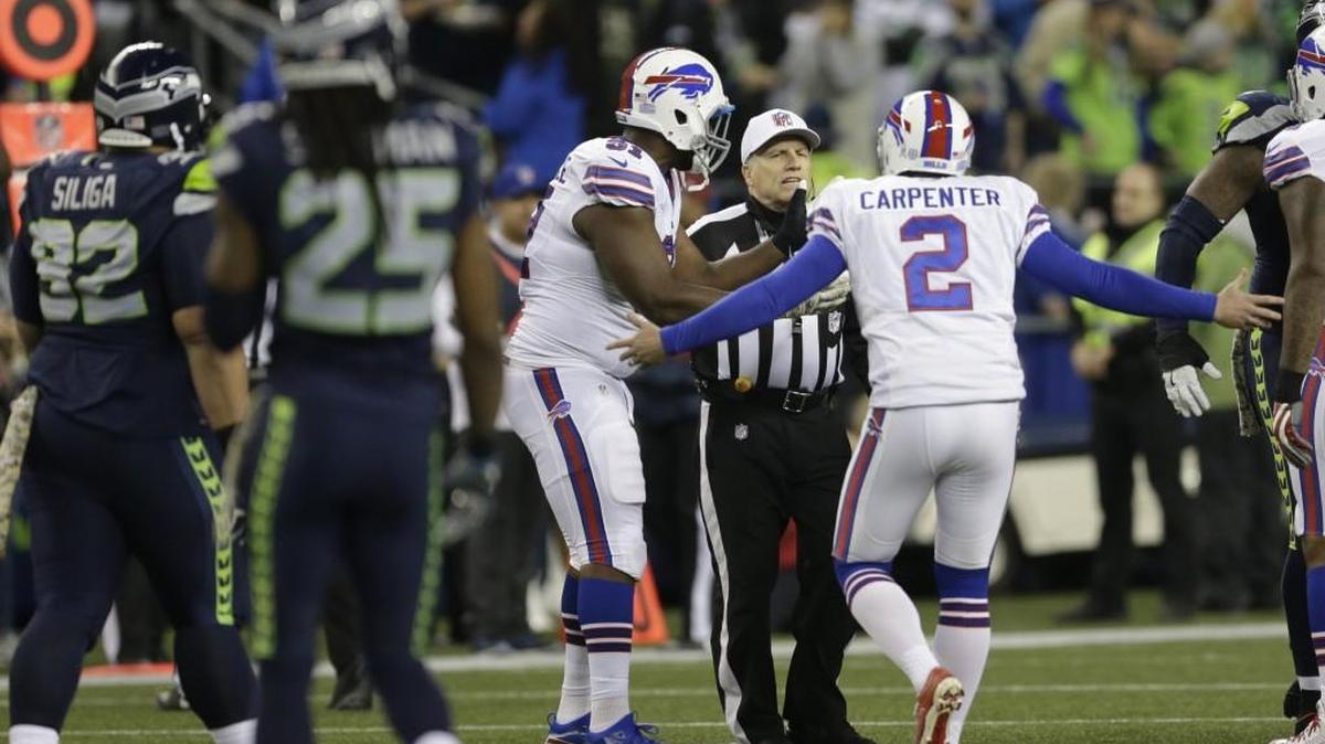 Bills kicker Dan Carpenter (2) complains to referee Walt Anderson late in the first half Monday night after Richard Sherman ran offside then blocked a field-goal try and hit Carpenter doing it.