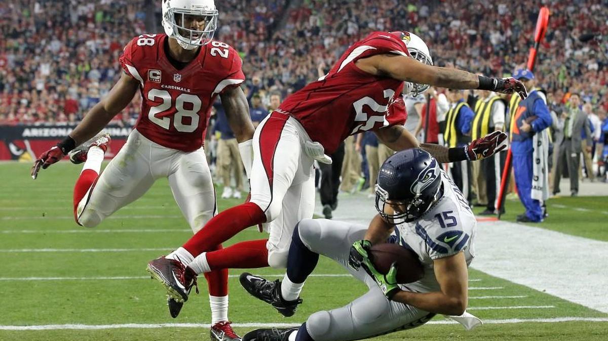 Seattle Seahawks wide receiver Jermaine Kearse (15) falls into the end zone for a touchdown as Arizona Cardinals free safety Rashad Johnson (26) and cornerback Justin Bethel (28) defend during the first half of an NFL football game, Sunday, Jan. 3, 2016, in Glendale, Ariz.