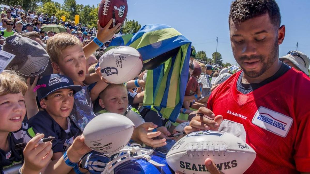 Quarterback Russell Wilson is always a popular autograph for fans at Seahawks training camp, as he was here last July 31 at the Virginia Mason Athletic Center in Renton.