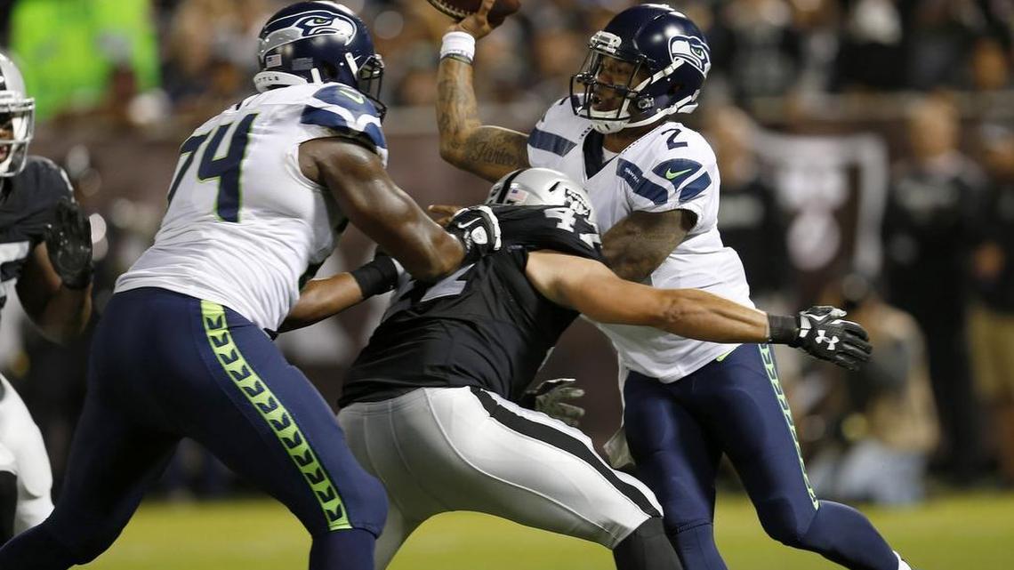 Seattle Seahawks quarterback Trevone Boykin (2) attempts to pass as he's pressured by the Oakland Raiders' James Cowser (47) during a play which resulted in a safety for the Raiders in the second quarter of preseason action at the Coliseum in Oakland Thursday.