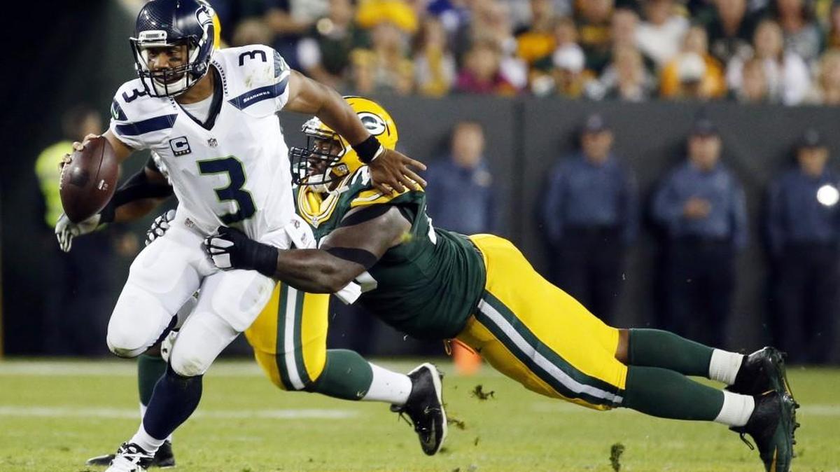 
Green Bay Packers' Mike Daniels tries to stop Seattle Seahawks' Russell Wilson (3) during the first half of an NFL football game Sunday, Sept. 20, 2015, in Green Bay, Wis.
