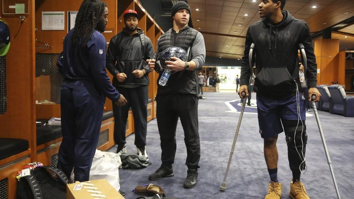 Cornerback DeShawn Shead, on crutches far right, talks with Seahawks teammates, from left, Alex Collins, K.J. Wright and Brock Coyle in the team’s locker room at its Renton headquarters Jan. 15, the day after Seattle’s playoff loss at Atlanta. Shead posted on Twitter that he had successful knee surgery on Friday.