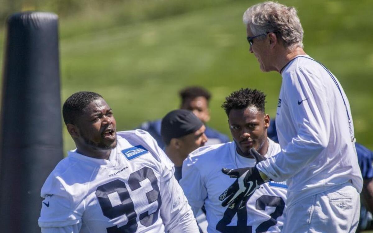 Coach Pete Carroll talks during Seahawks minicamp this month with rookie defensive tackle Jaran Reed at the Virginia Mason Athletic Center in Renton. That’s where the team is having the first of nine organized team activity days on the field this week.